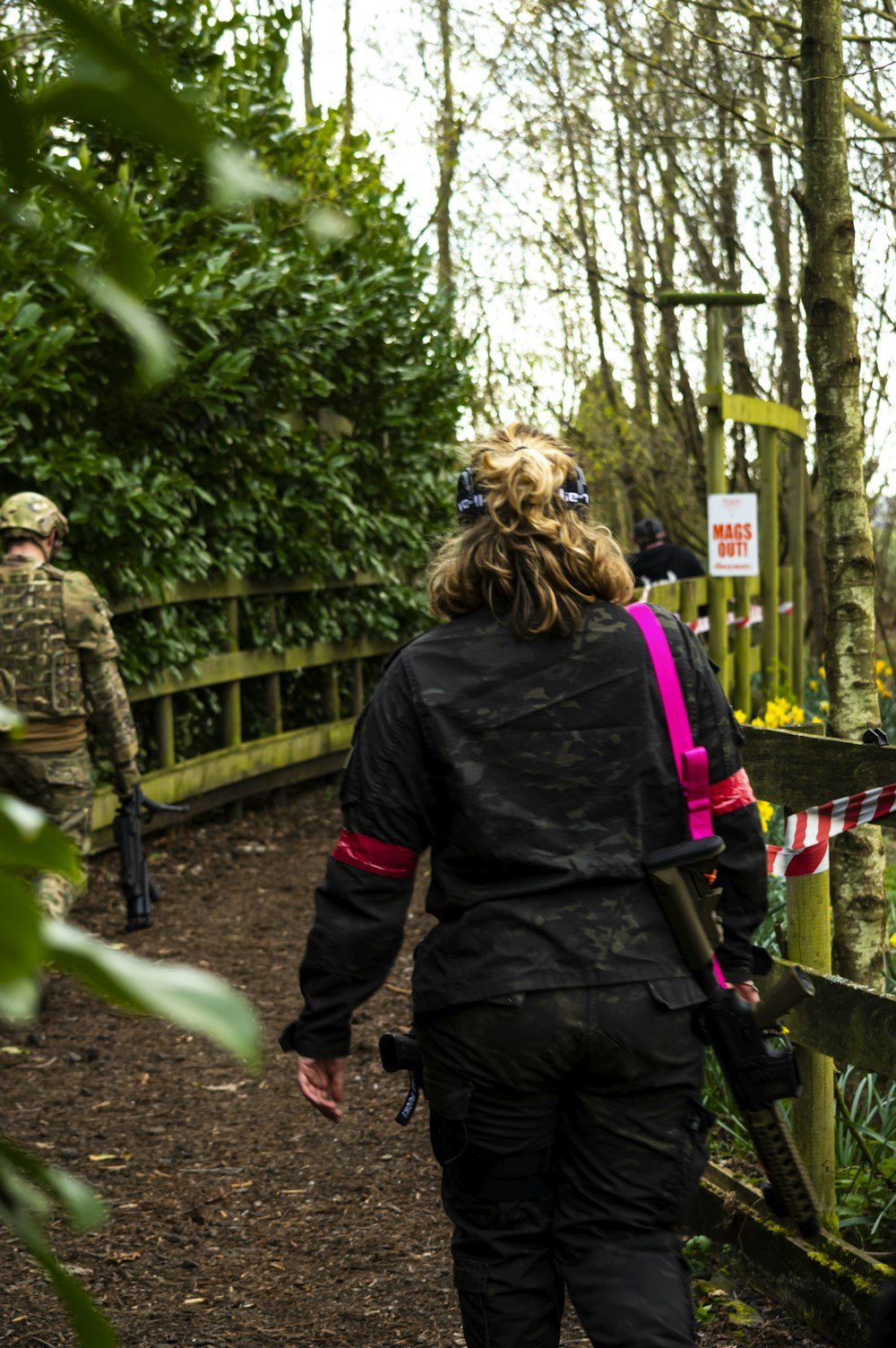 a group of people walking down a path in the woods