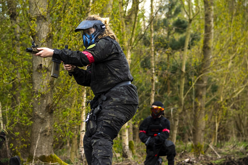 a woman in a black jacket is shooting a gun