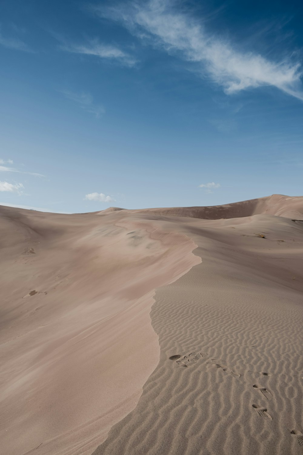 a person walking across a large sandy field