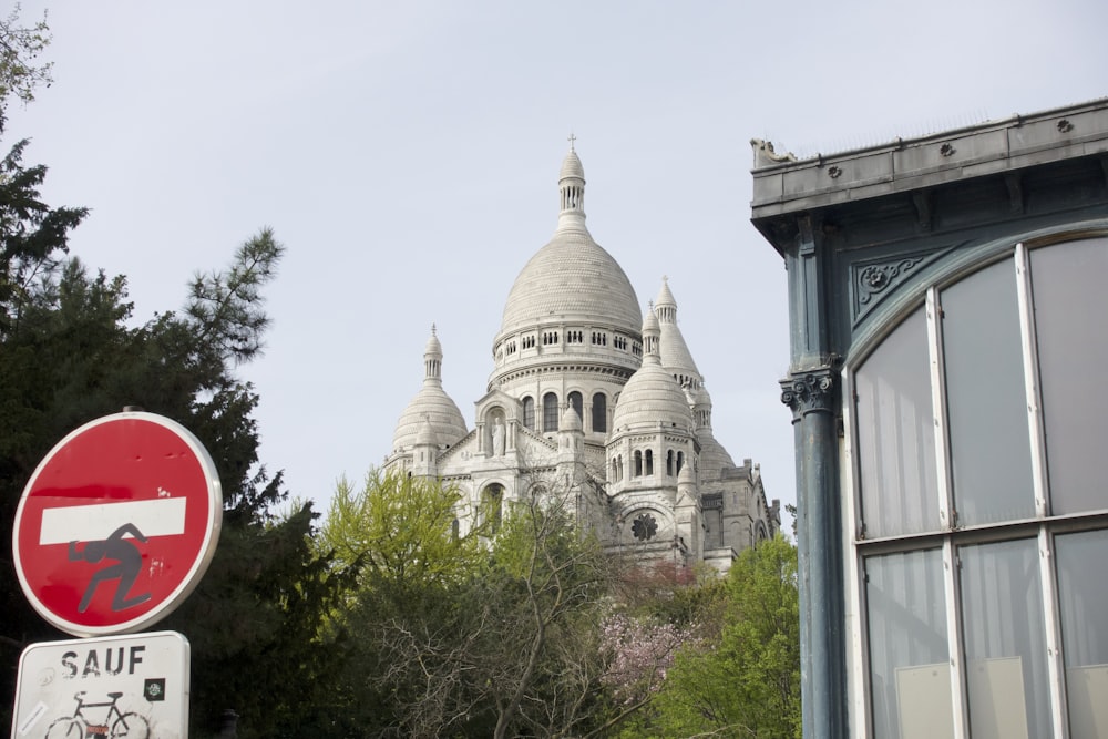 a red and white street sign next to a tall building