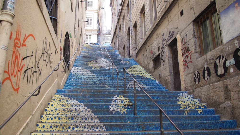 a set of blue stairs with graffiti painted on them