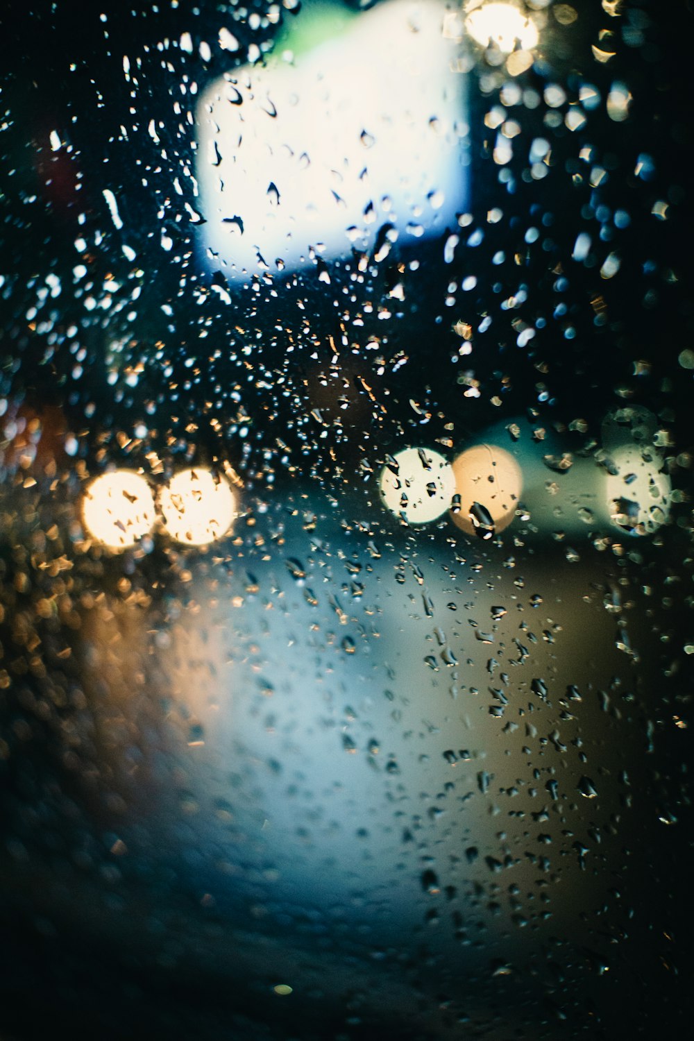 rain drops on the windshield of a car at night