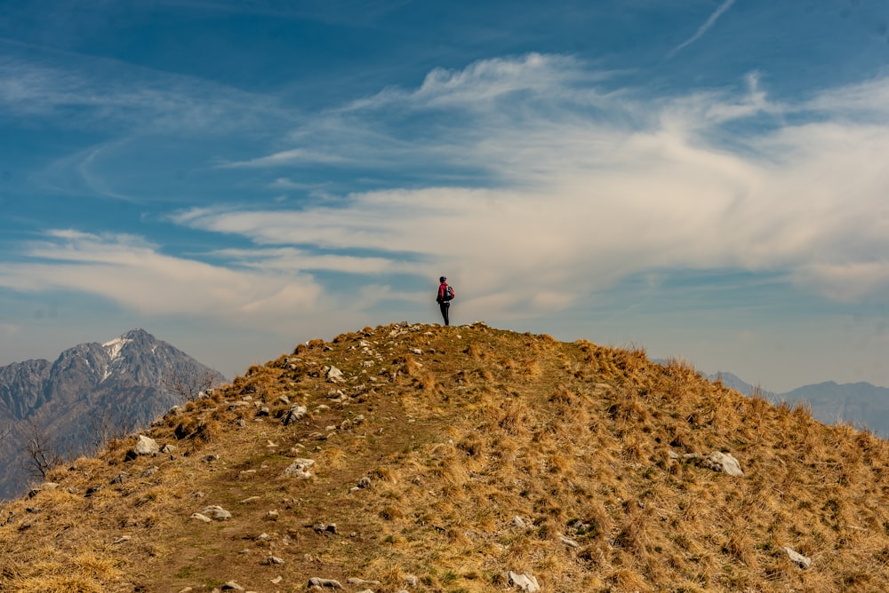 a person standing on top of a grass covered hill