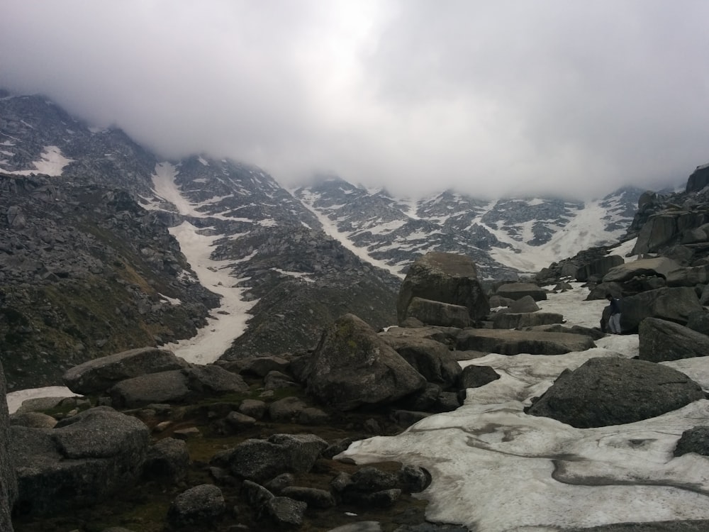 a rocky mountain with snow on the ground