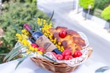 a basket filled with bread, tomatoes and a bottle of wine