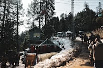 Guests stepping off a shuttle bus onto a wooden deck surrounded by snow-dusted evergreens.
