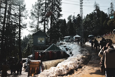 Guests stepping off a shuttle bus onto a wooden deck surrounded by snow-dusted evergreens.