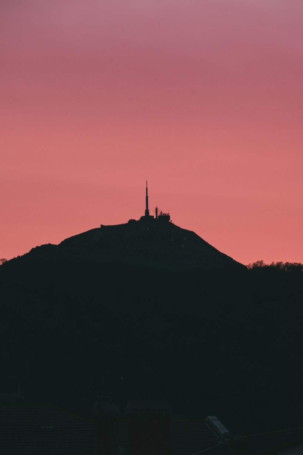a silhouette of a hill with a building on top