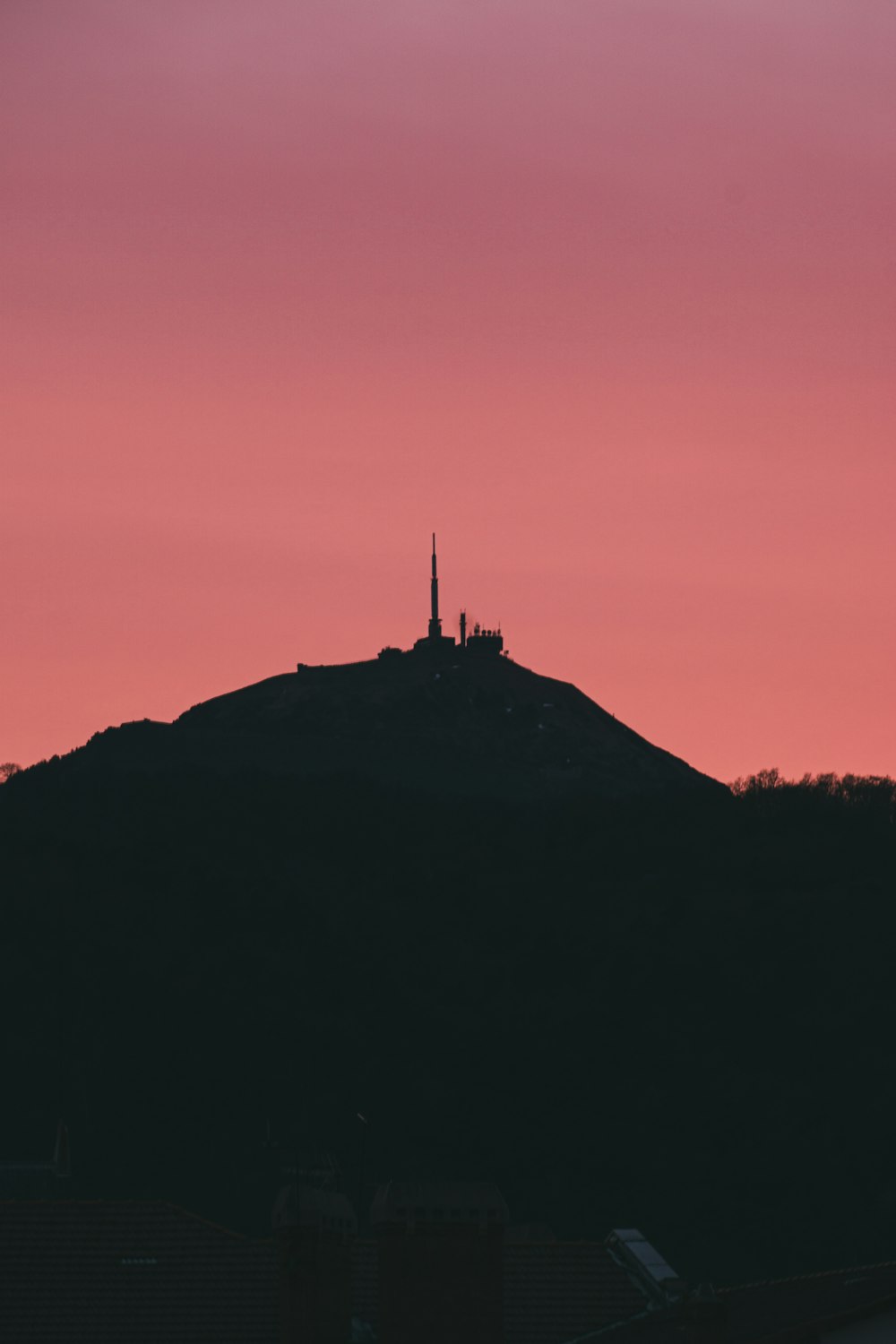 uma silhueta de uma colina com um edifício no topo