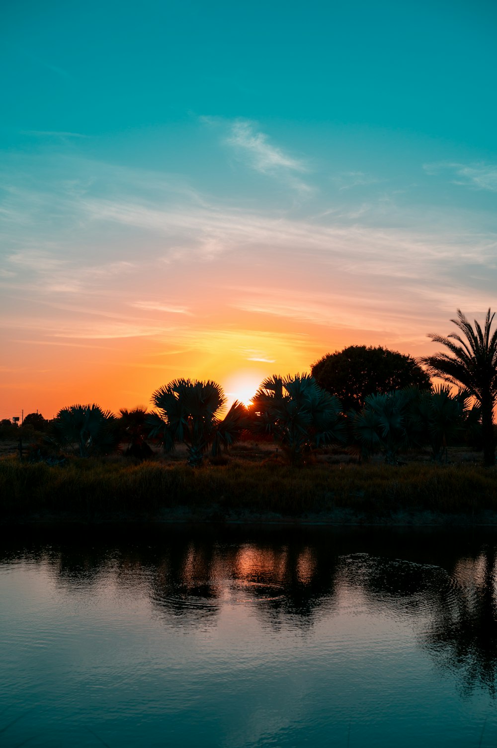 the sun is setting over a body of water