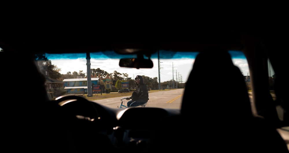 a man riding a motorcycle down a street next to a traffic light