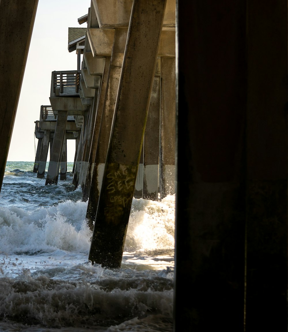 a view of the ocean from under a pier