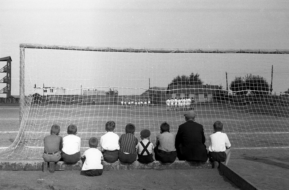 a group of people sitting in front of a soccer goal