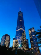 High-quality image of a modern glass tower illuminated at dusk.