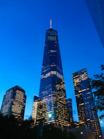 Evening view of a completed commercial building illuminated against the night sky.
