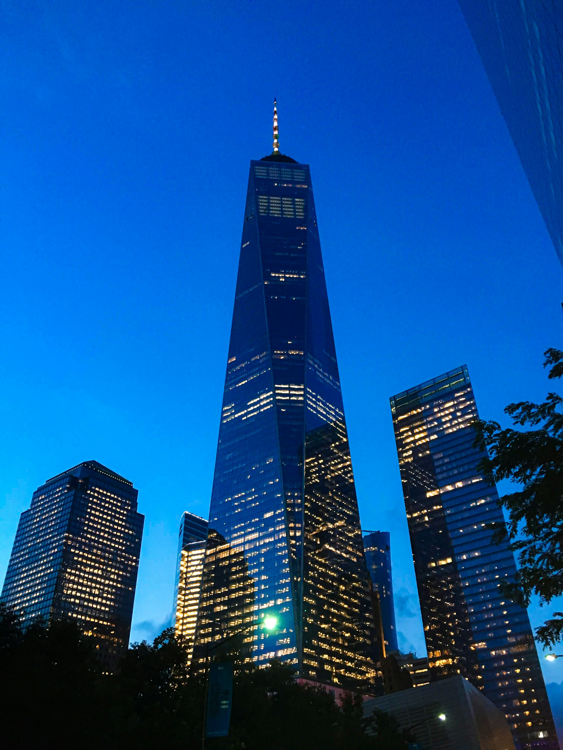 A striking nighttime view of a newly completed skyscraper with illuminated glass facades reflecting city lights.