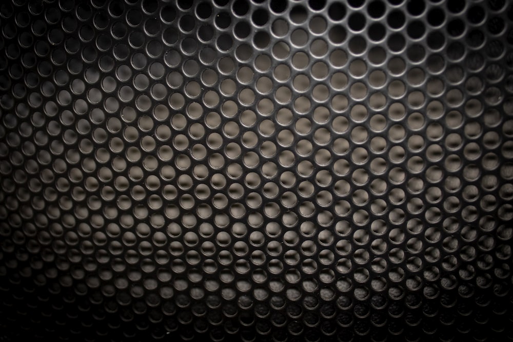 a close up of a metal surface with circles on it