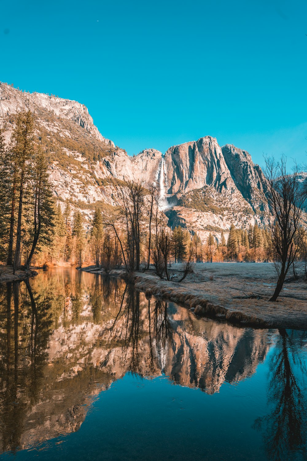 a mountain range is reflected in the still water of a lake