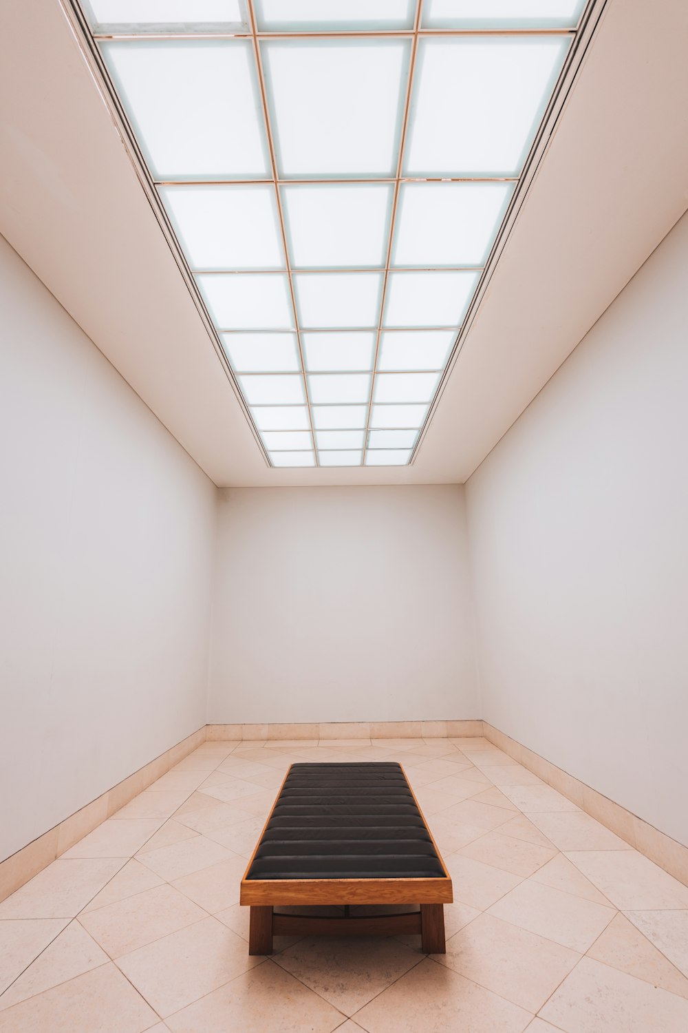 an empty room with a wooden bench in the middle