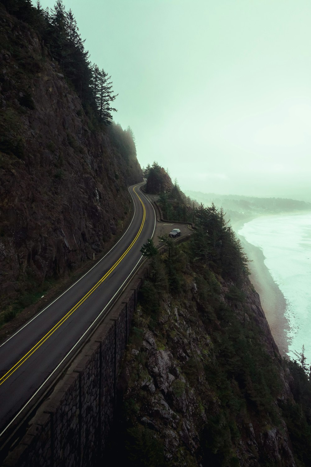 a car driving down a road next to the ocean