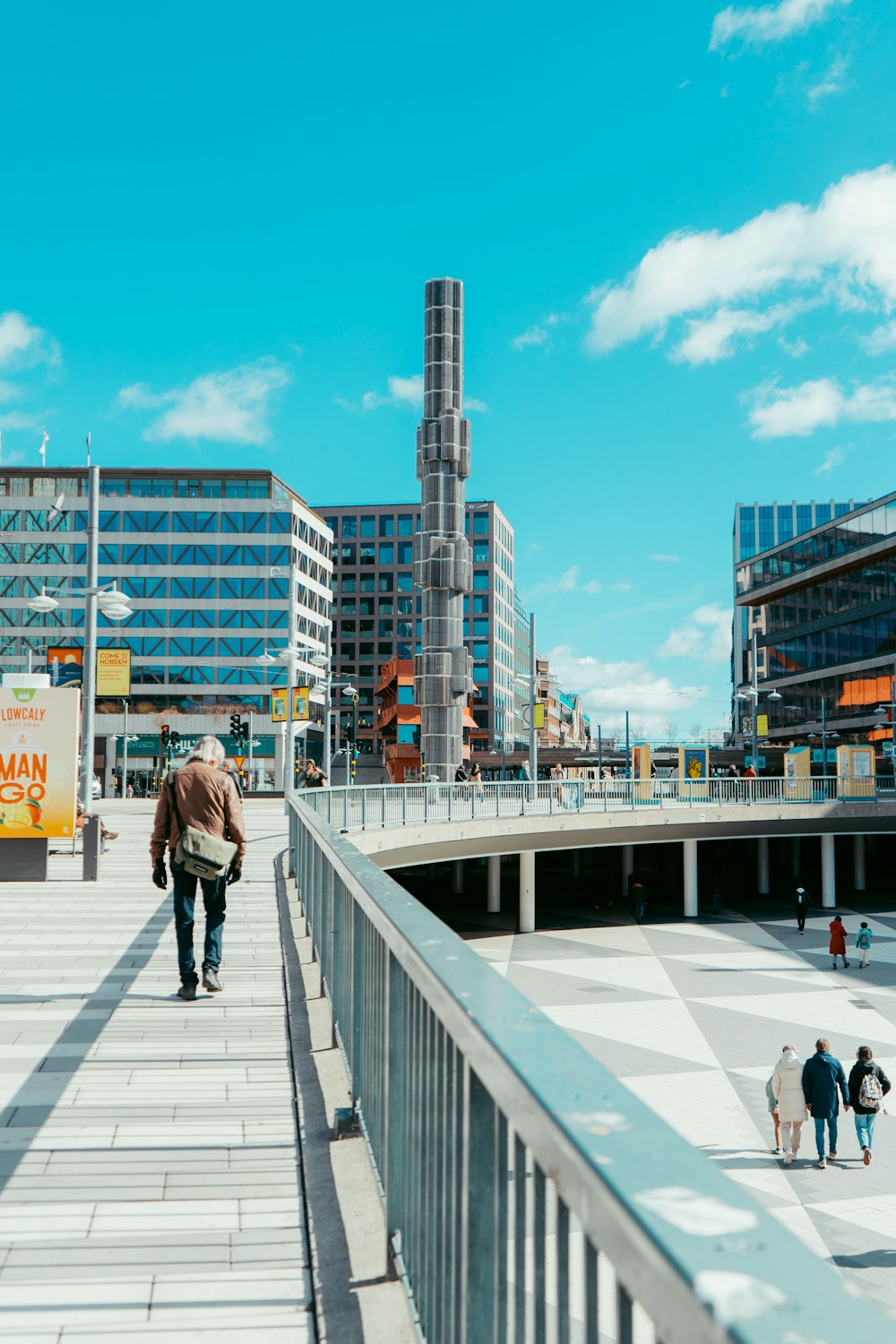 a man walking down a walkway in a city