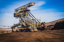 a large yellow crane sitting on top of a dirt field