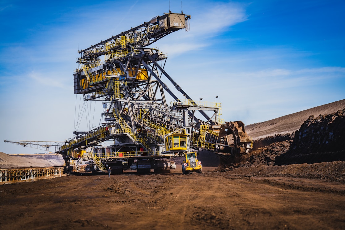 a large yellow crane sitting on top of a dirt field