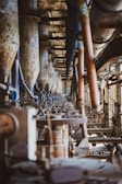 a row of machines in a factory with lots of pipes