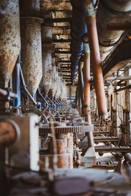 a row of machines in a factory with lots of pipes