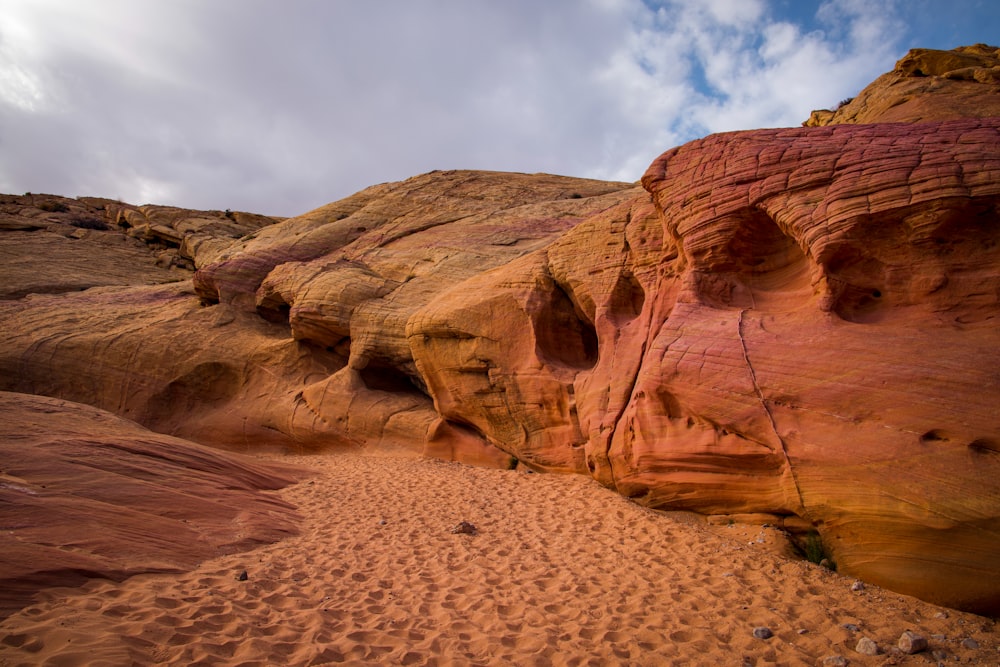 a large rock formation with a sky in the background