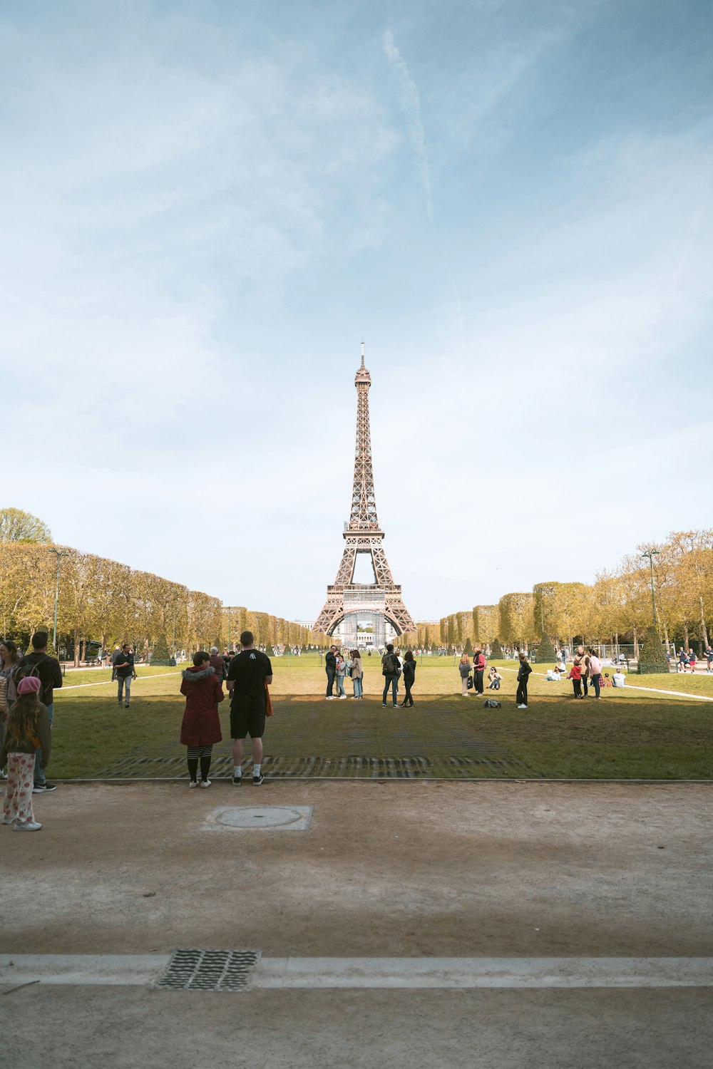 a group of people standing in front of the eiffel tower