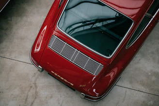 a red car parked in a garage next to another car