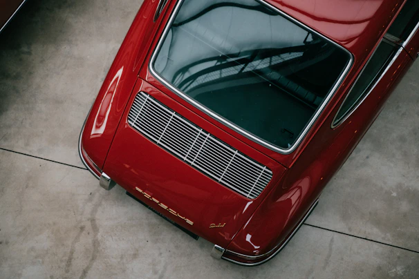 a red car parked in a garage next to another car