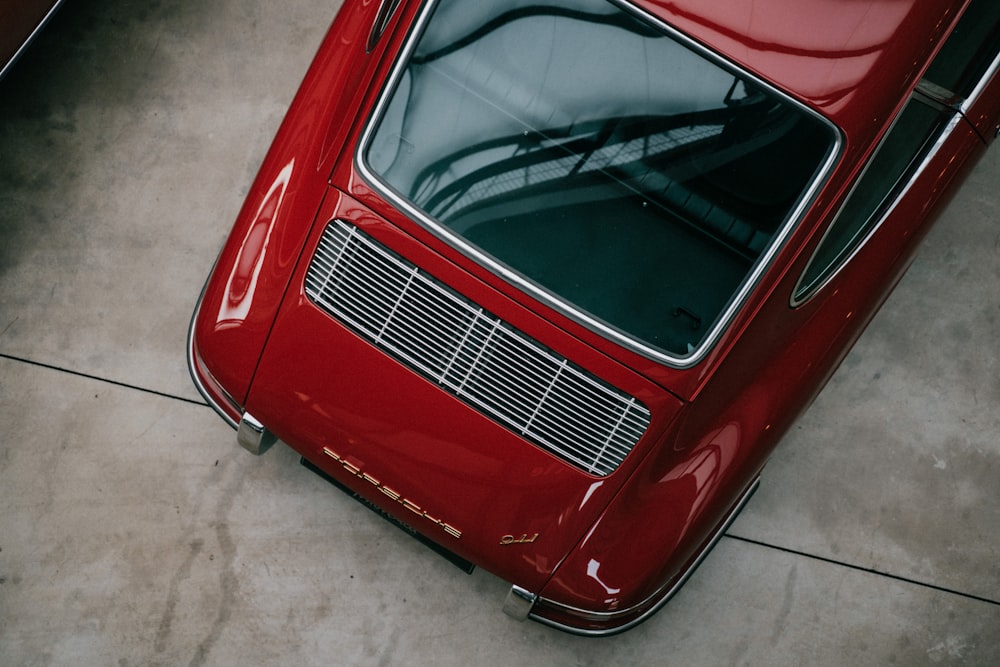 a red car parked in a garage next to another car