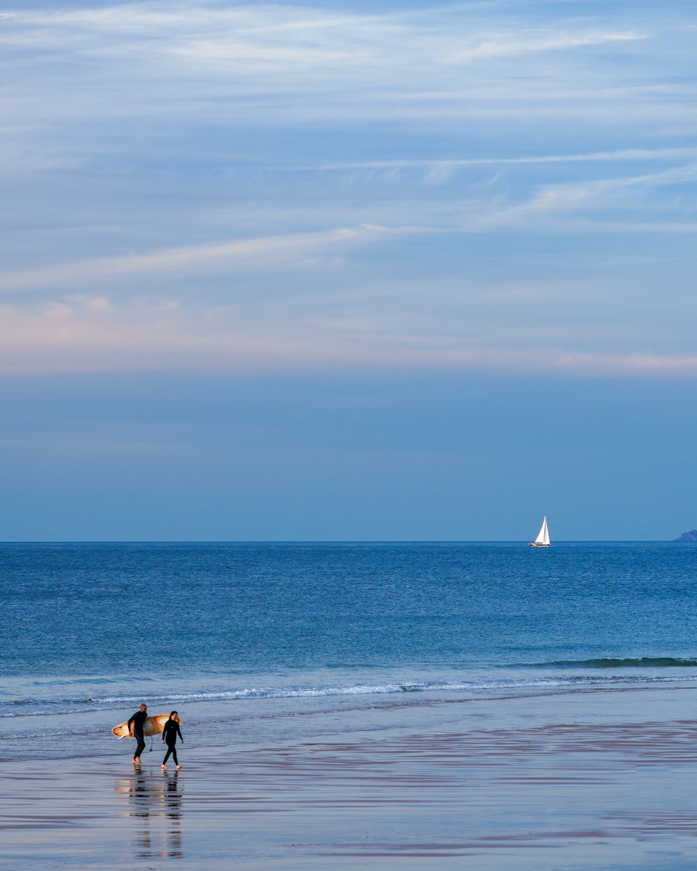 a person carrying a surfboard on a beach