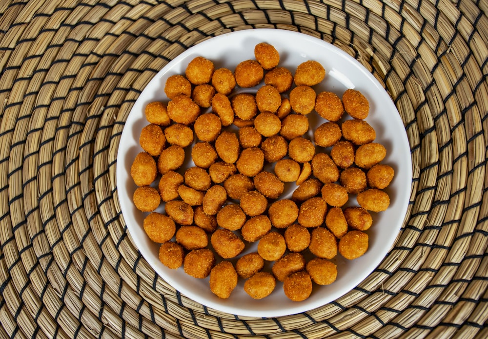 a white bowl filled with fried food on top of a table