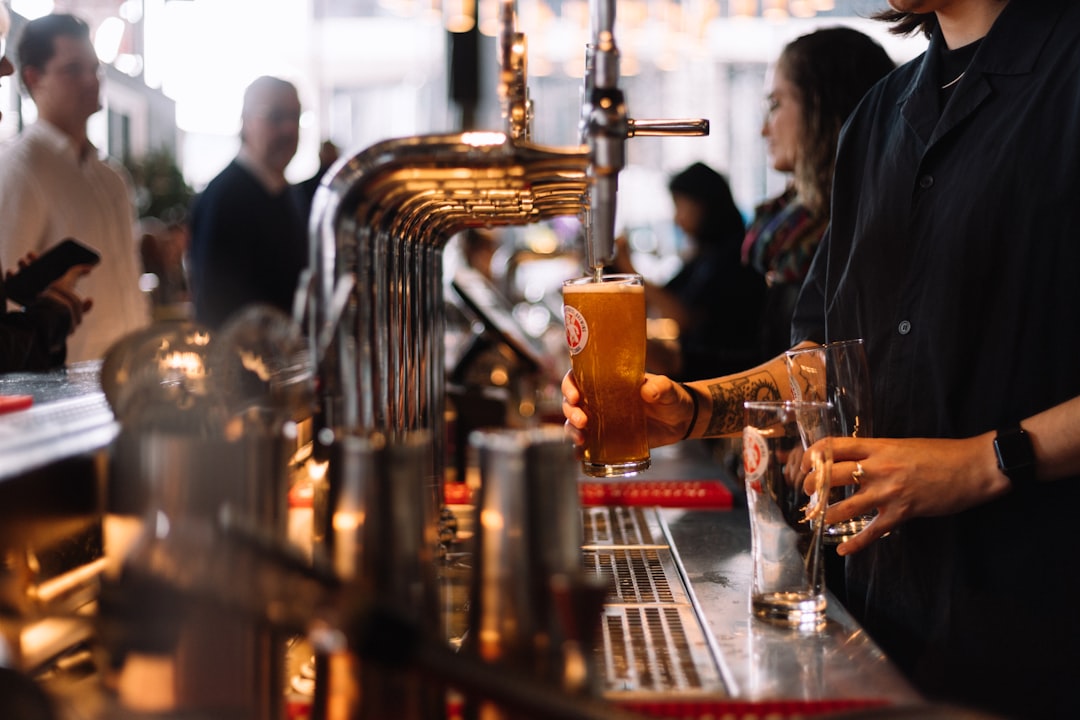 a man pouring a drink at a bar, Pint of craft beer being poured at Little Creatures bar in London
