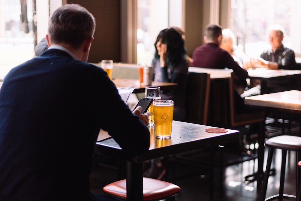 a man sitting at a table with a glass of beer