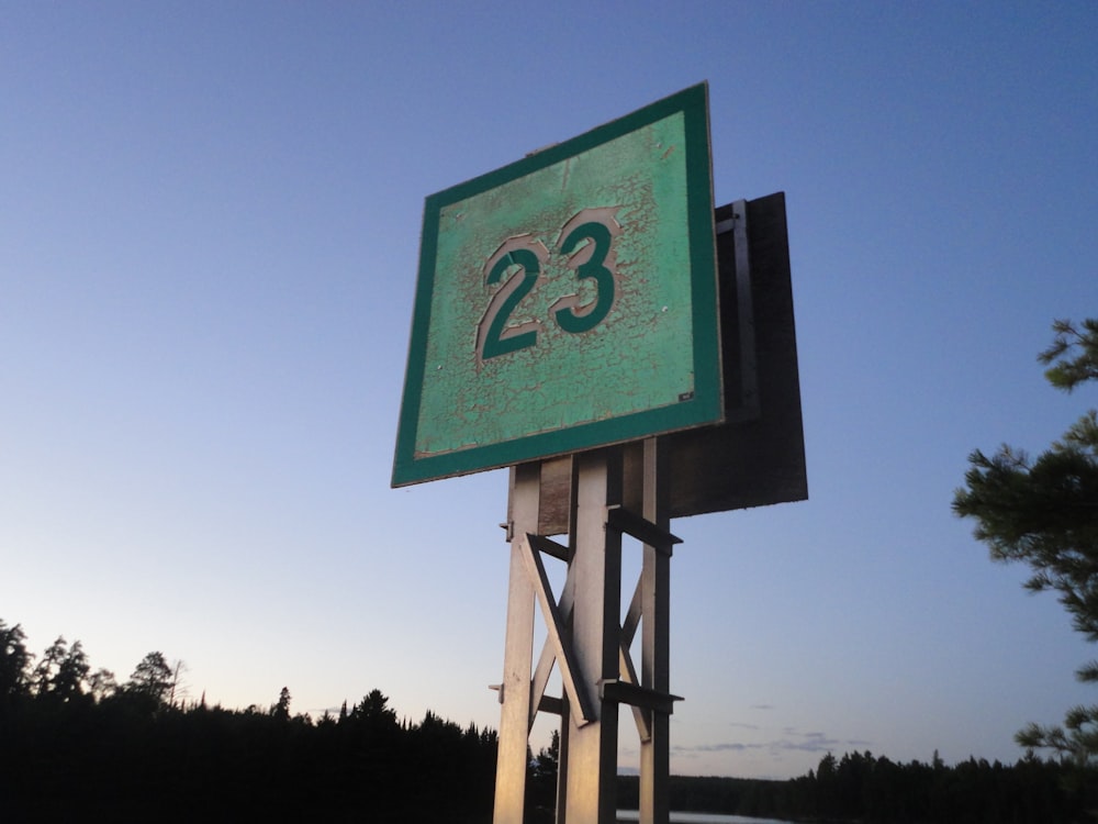 a green sign with the number twenty three on it