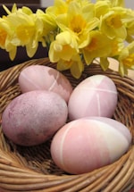 Close-up of colorful eggs in a rustic basket.