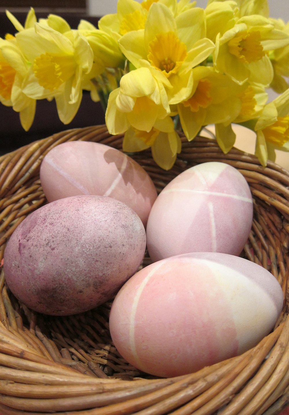 a wicker basket filled with eggs and yellow flowers