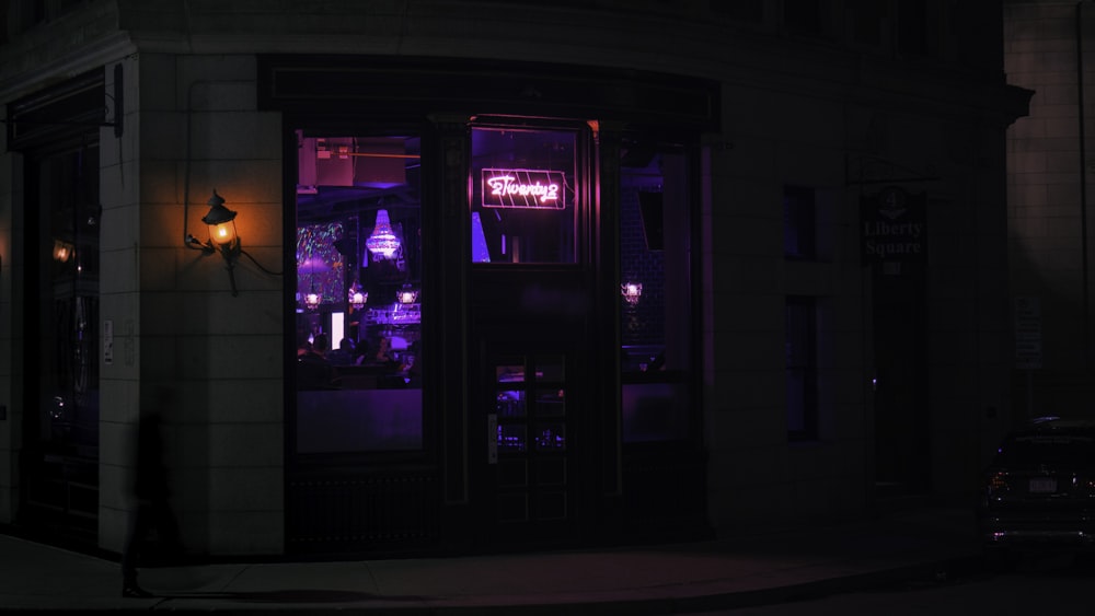 a dark street corner with a store front lit up at night