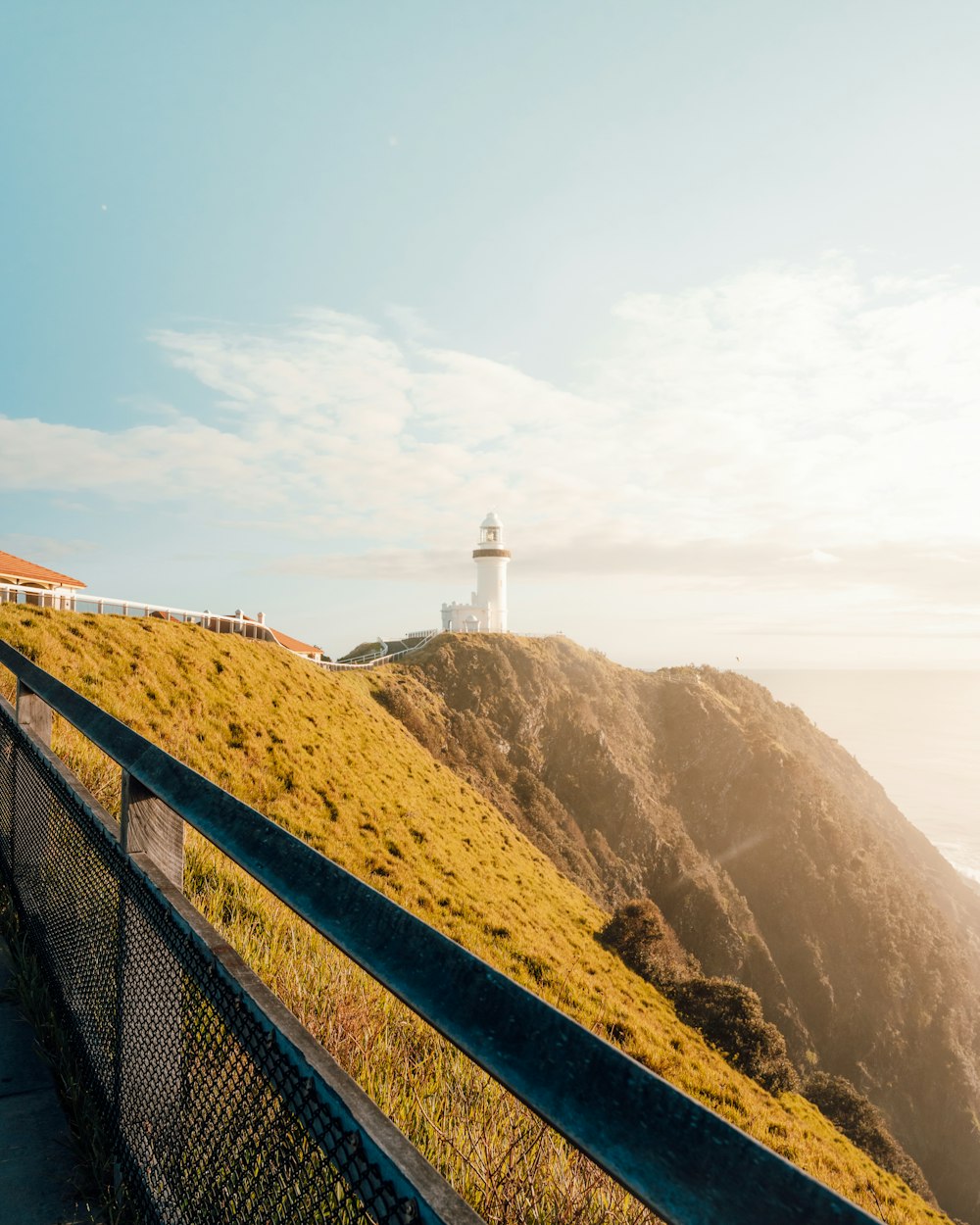 a lighthouse on top of a hill near the ocean