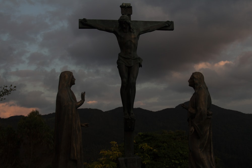 Una estatua de Jesús en la cruz con dos mujeres