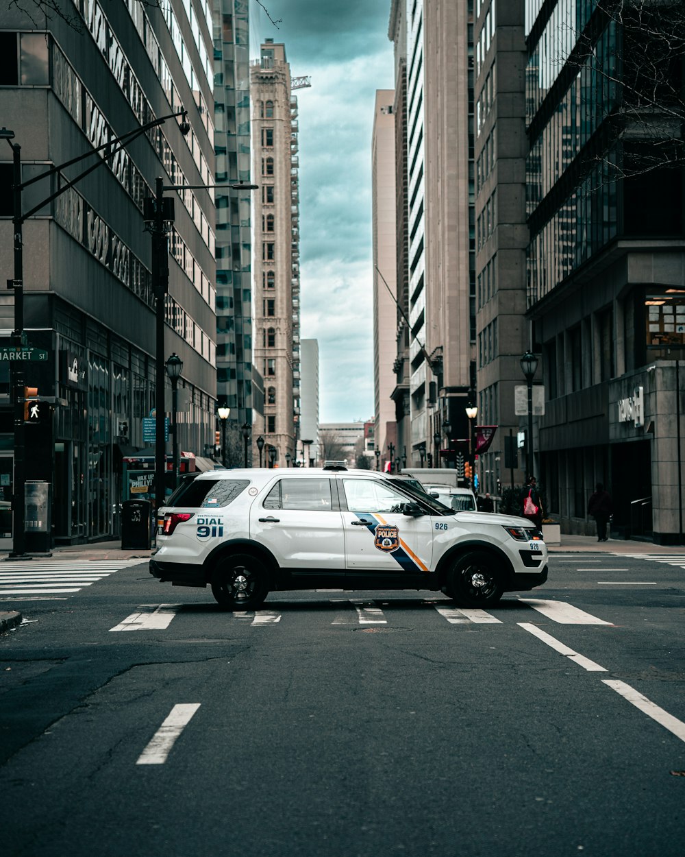 a white van driving down a street next to tall buildings