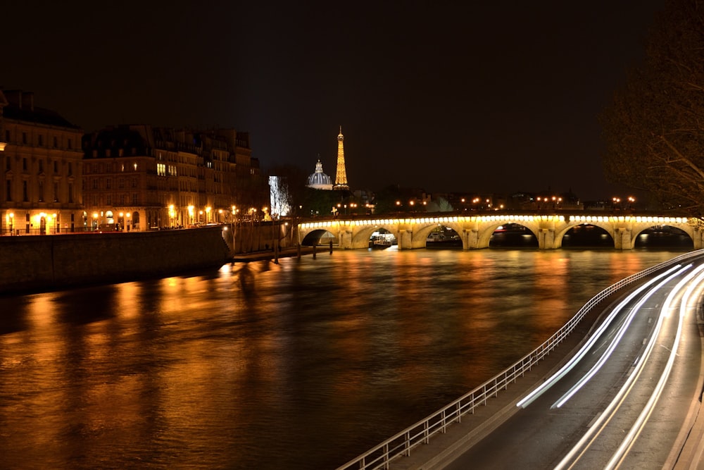 a night time view of a river and a bridge