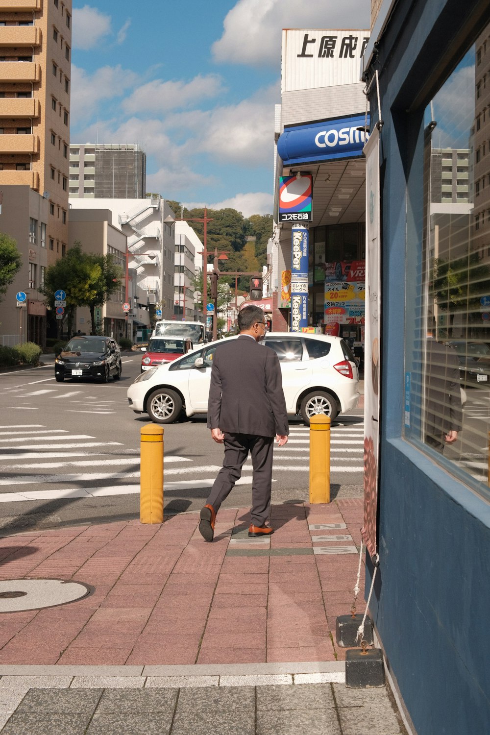 a man walking down a sidewalk in front of a store