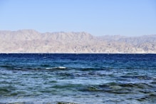 a large body of water with mountains in the background