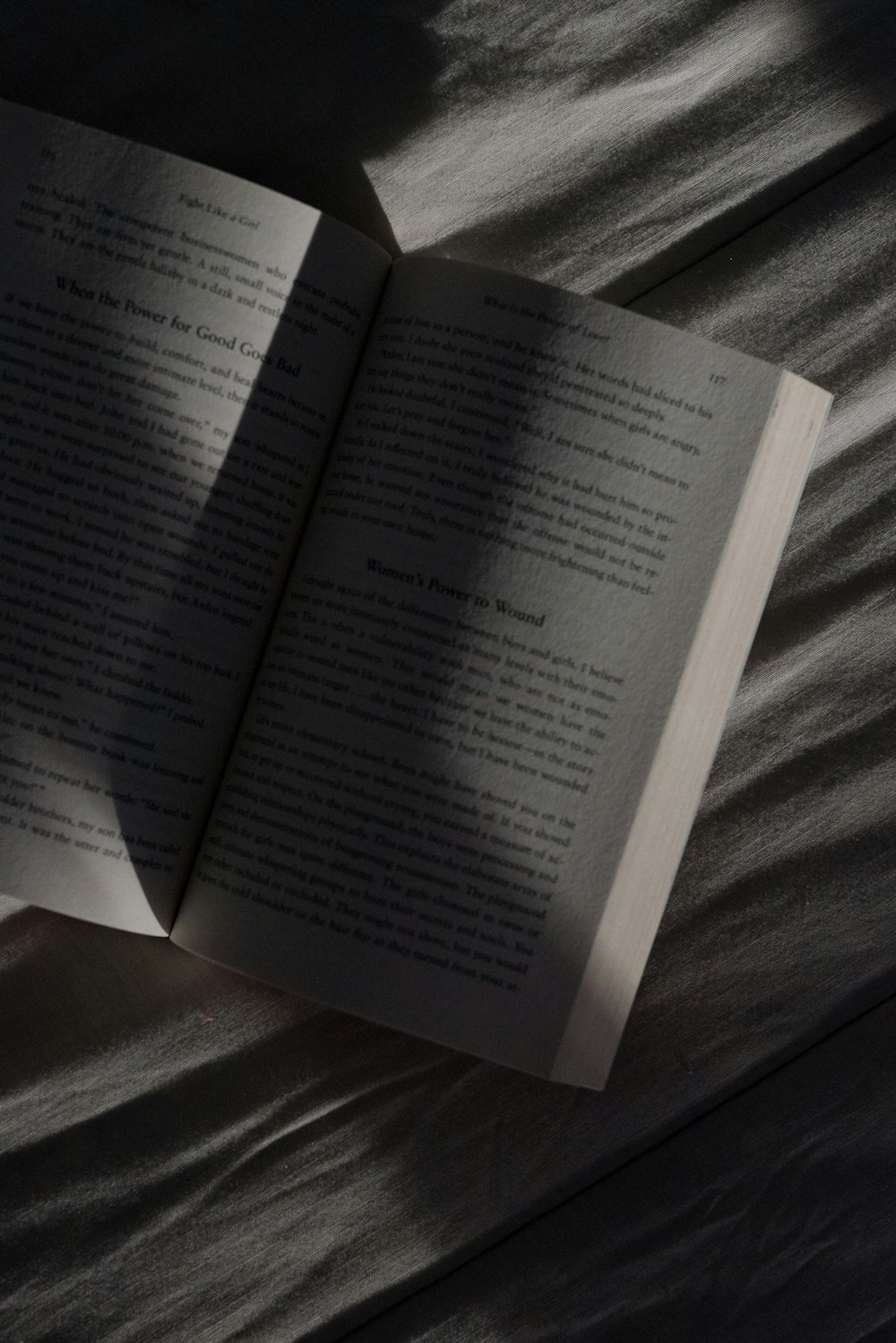 an open book sitting on top of a bed