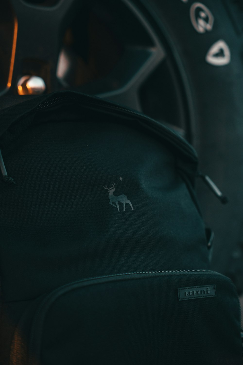 a close up of a black backpack with a deer on it